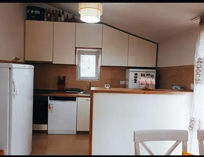 a kitchen with white cabinets and a white refrigerator at Bgd 2 apartman in Kotor