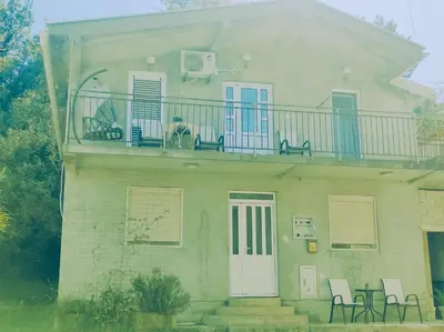 a house with a balcony with chairs on it at Bgd 2 apartman in Kotor