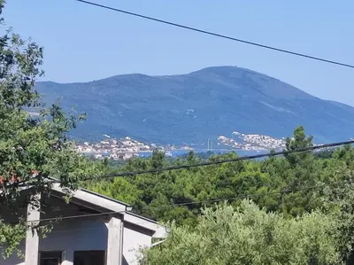 a view of a mountain from a house with trees at Bgd 2 apartman in Kotor