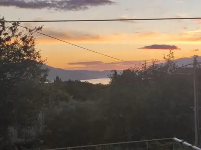 a sunset view of the mountains with trees at Bgd 2 apartman in Kotor