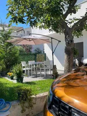 a patio with an umbrella and a table and chairs at Jeja Apartments in Sutomore