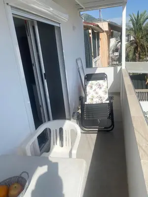 a white chair sitting on a balcony with a grill at Jeja Apartments in Sutomore