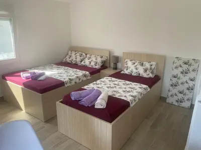 two twin beds in a room with at Jeja Apartments in Sutomore