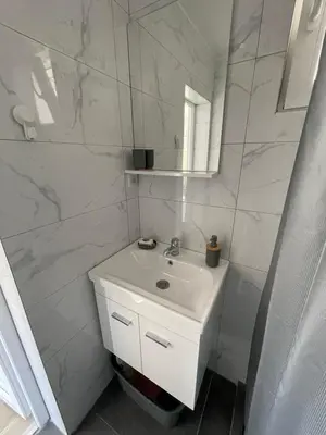 a white bathroom with a sink and a mirror at Jeja Apartments in Sutomore