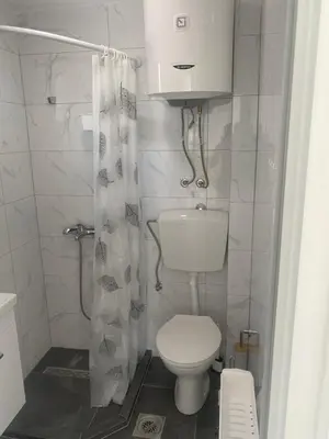 a small bathroom with a toilet and a shower at Jeja Apartments in Sutomore