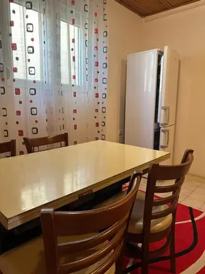 a kitchen with a table and chairs and a refrigerator at Apartmani VV in Cetinje