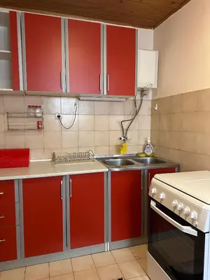 a kitchen with red cabinets and a sink at Apartmani VV in Cetinje