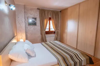 a bedroom with a white bed with a window at Villa Brda in Petrovac na Moru