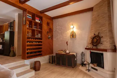 a living room with a fireplace and a room with a table at Villa Brda in Petrovac na Moru