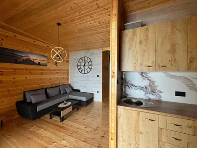 a living room with a couch and a clock on the wall at Kućica Ušće - Ada Bojana in Ulcinj