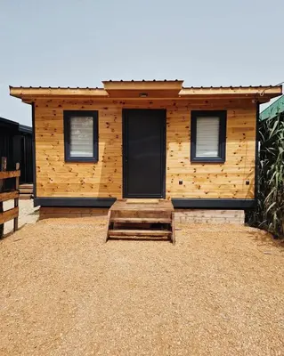 a wooden cabin with two windows and a porch at Kućica Ušće - Ada Bojana in Ulcinj