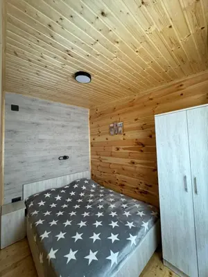 a bed in a room with a wooden ceiling at Kućica Ušće - Ada Bojana in Ulcinj