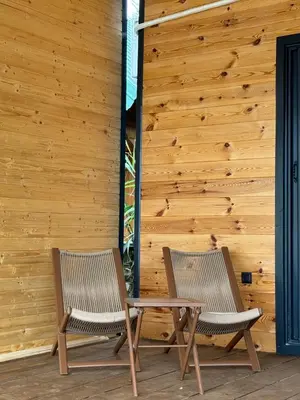 two chairs sitting in front of a wooden wall at Kućica Ušće - Ada Bojana in Ulcinj