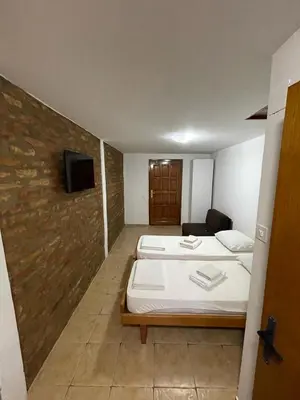 a hotel room with two beds and a television at Cozy Place in Utjeha