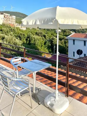 a table and chairs on a deck with an umbrella at Cozy Place in Utjeha