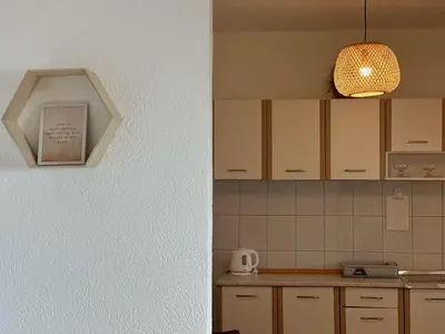 a kitchen with white cabinets and a light fixture at Seas the day - Apartment with sea view and terrace in Ulcinj