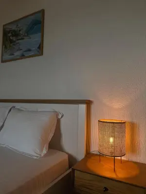 a lamp on a night stand next to a bed at Seas the day - Apartment with sea view and terrace in Ulcinj
