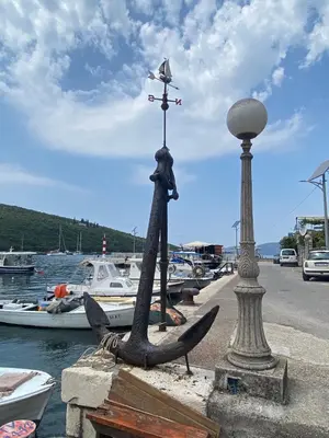 a statue of a boat on a dock with boats in the water at Apartman u zelenilu Bigove in Kotor