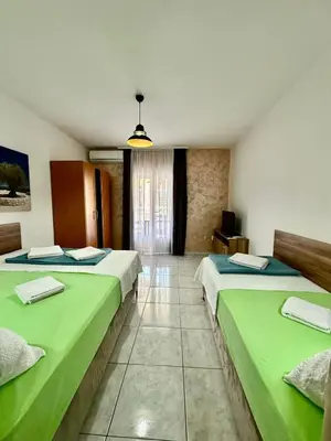 two beds in a room with green sheets at Villa IL Mare in Budva