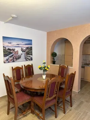 a dining room with a wooden table and chairs at Villa IL Mare in Budva