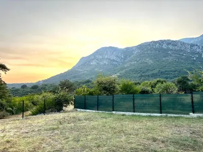 a fence in a field with mountains in the background at Oak valley in Bar