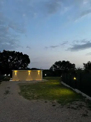 a building with lights in a yard at night at Oak valley in Bar