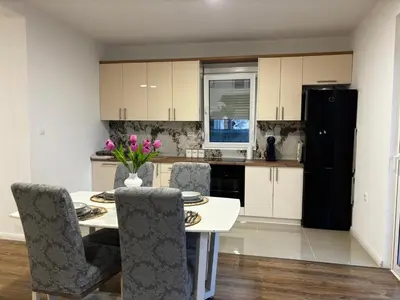 a kitchen with a table and chairs and a black refrigerator at Oak valley in Bar