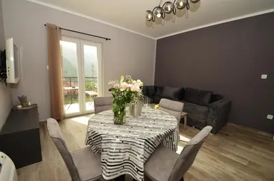 a living room with a table with flowers on it at Apartments Orizzonte with beautiful view of the bay in Kotor