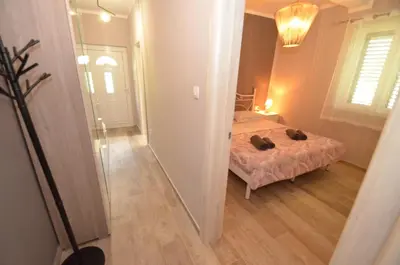 a small bedroom with a bed and a mirror at Apartments Orizzonte with beautiful view of the bay in Kotor