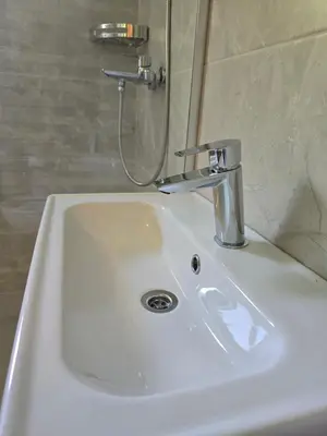 a white sink in a bathroom with a shower at Apartman Cetinje in Cetinje