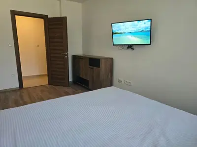 a bedroom with a bed and a flat screen tv at Apartman Cetinje in Cetinje