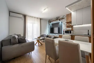 a kitchen and living room with a table and chairs at Hillside Apartments in Becici