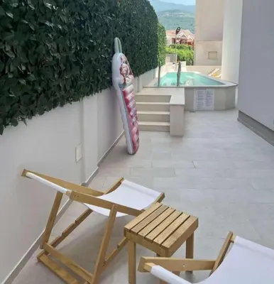 a patio with two chairs and a large vase at Horizont studio in Becici