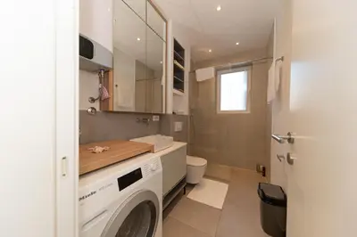 a bathroom with a washing machine and a toilet at Horizont studio in Becici