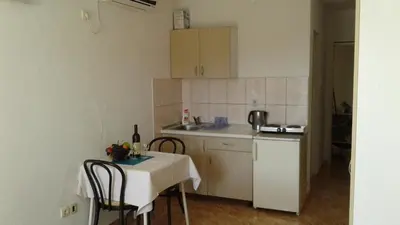 a small kitchen with a table and a table and chairs at Apartmani Neda Bane in Petrovac na Moru