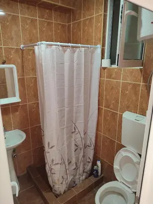 a bathroom with a toilet and a shower curtain at Blazo apartments in Ulcinj