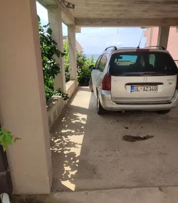 a small white car parked in a garage at Blazo apartments in Ulcinj
