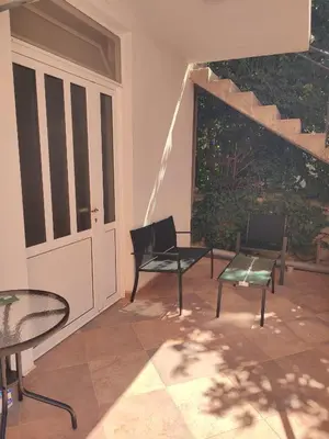a patio with two chairs and a table and a window at Blazo apartments in Ulcinj