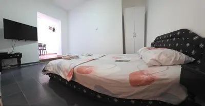 a large bed in a room with a television at Blazo apartments in Ulcinj