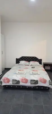 a bed in a room with a white wall at Blazo apartments in Ulcinj