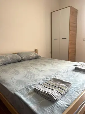 a bedroom with a bed with a dresser and a mirror at Blazo apartments in Ulcinj