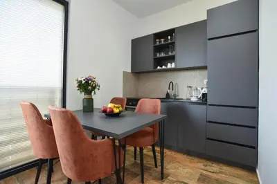 a kitchen with a black table and orange chairs at Residenza Apartments in Kotor