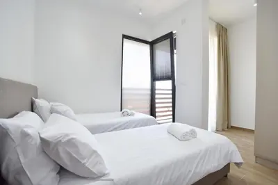 two beds in a room with a window at Residenza Apartments in Kotor