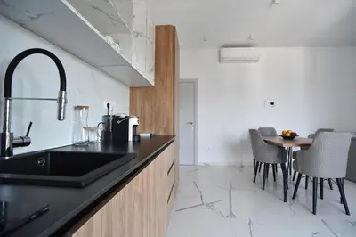 a kitchen with a sink and a table with chairs at Residenza Apartments in Kotor