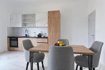 a wooden table with chairs and a bowl of fruit on it at Residenza Apartments in Kotor