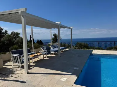 a swimming pool with chairs and a pavilion next to a swimming pool at Casa Oliva Villa with private heating pools in Budva