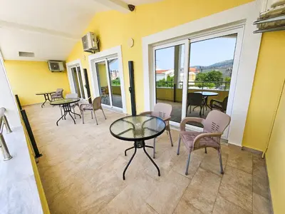 a room with a table and chairs and a balcony at Guesthouse Lole in Bar
