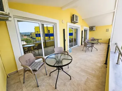 a living room with a glass table and chairs at Guesthouse Lole in Bar