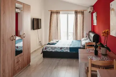 a bedroom with a bed and a table and a window at Guesthouse Lole in Bar