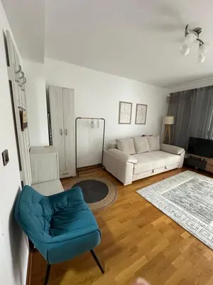 a living room with a couch and a blue chair at Apartment Studio in Budva